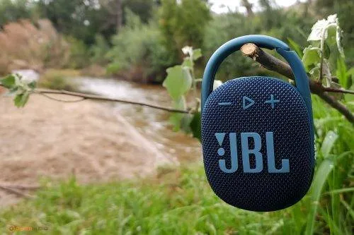 jbl clip speaker outdoors in a picnic hanging on a twig